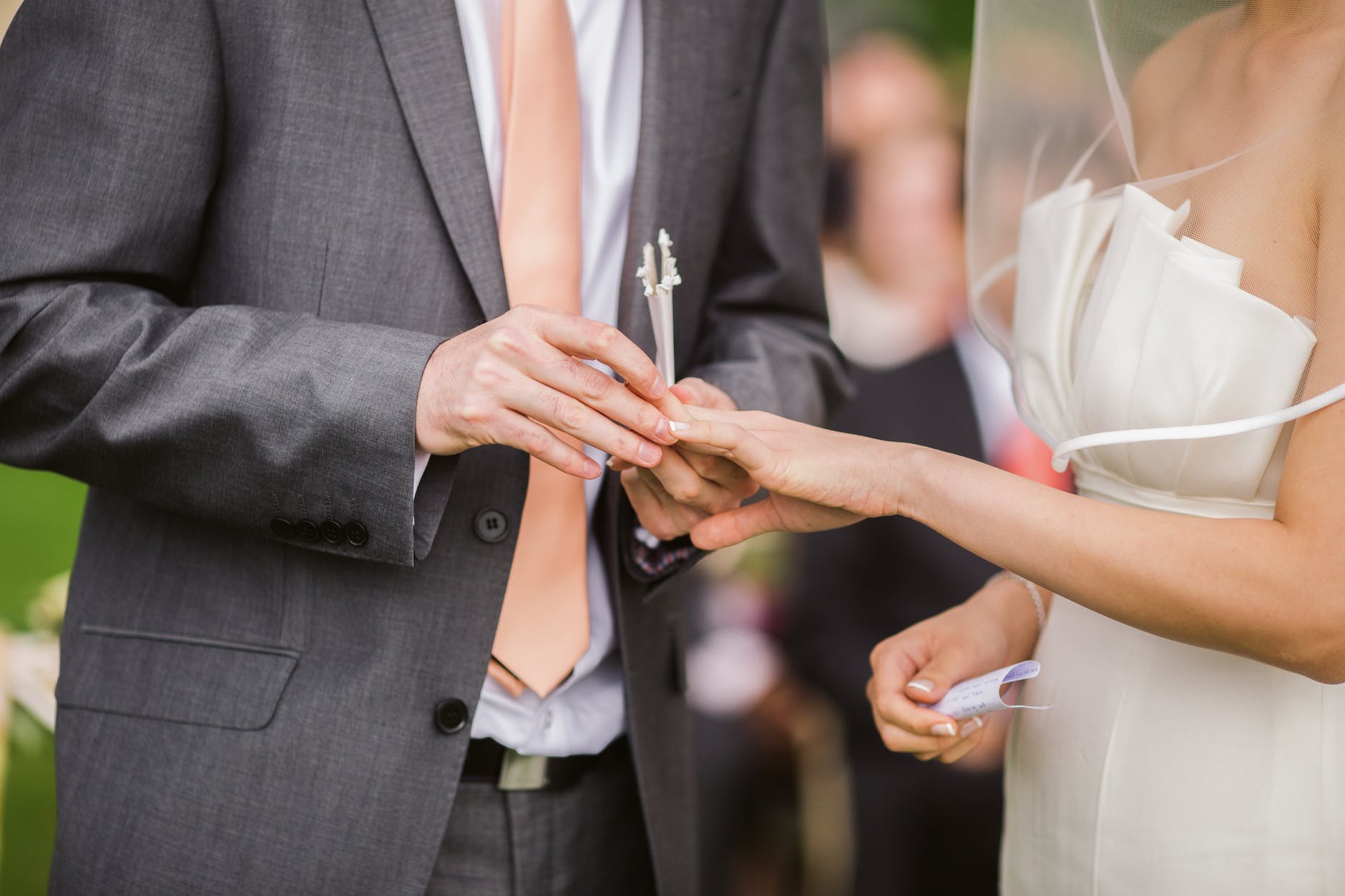 photo of groom putting wedding ring on his bride